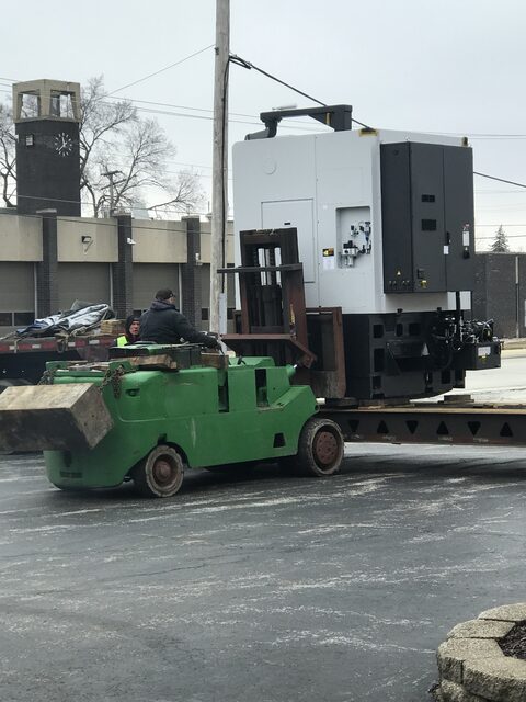 Carrying a CNC machining centre off the trailer on the forklift, winter street move