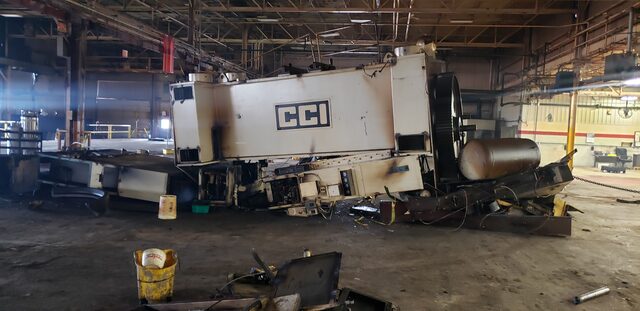 A machine laid over on its side and opened up, ready to come apart into truckable pieces