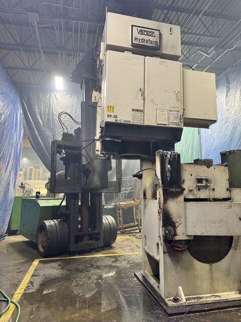 The same press cut down to pieces, our forklift alongside to carry the sections out