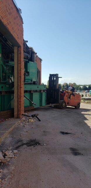 Carrying press sections out of the building on the forklift, straight through the wall opening