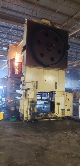 Cutting alongside the flywheel of a big press, torch working from a scissor lift