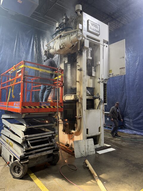 Cutting the press down with a torch from a scissor lift, containment hung to keep the sparks off the rest of the plant