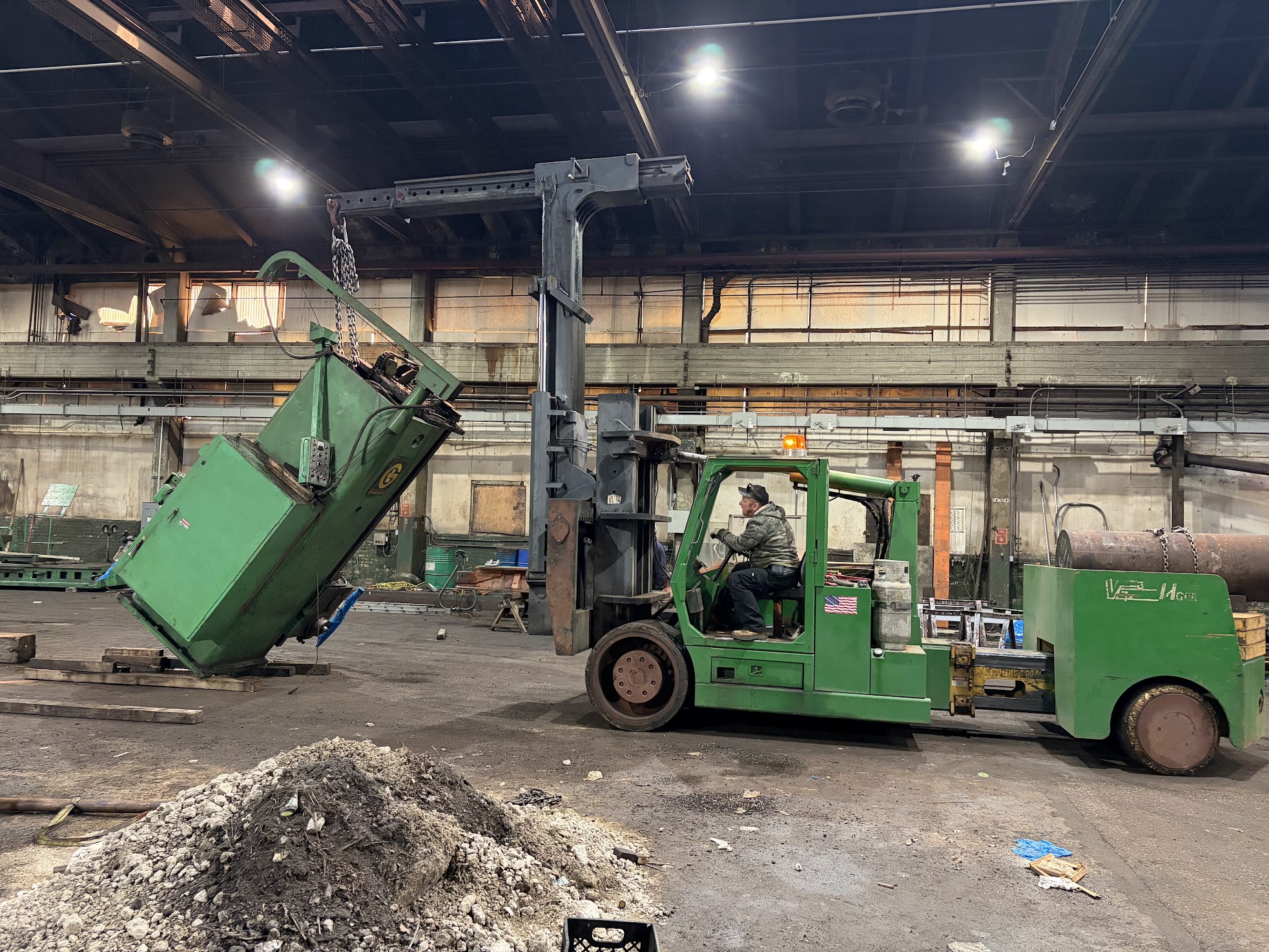 Our Versa-Lift with the boom attachment standing a heavy machine up on chains inside a plant during a removal