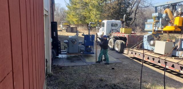 Guiding a Heian CNC router onto our step-deck - two riggers walking it back