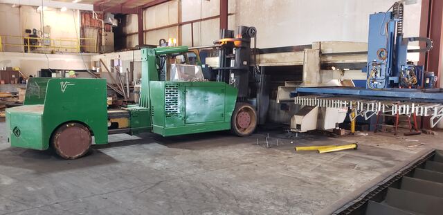 Walking a large press brake into position with our carry-deck forklift
