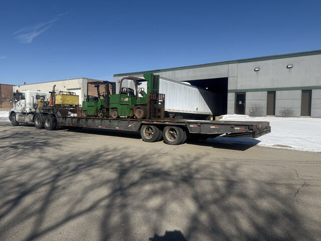 Two forklifts chained down on our step-deck at an Elk Grove dock, winter delivery