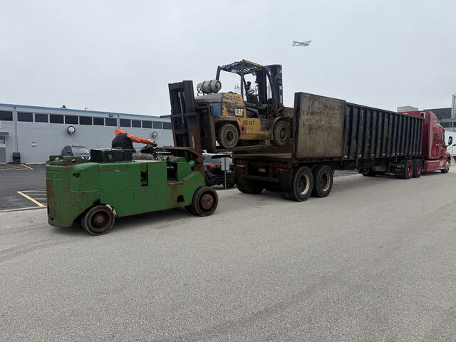 Unloading our beautiful CAT forklift -- O'Hare jet overhead, as always in Elk Grove