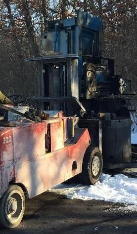 Our 30,000 lb forklift carrying an old press out in winter
