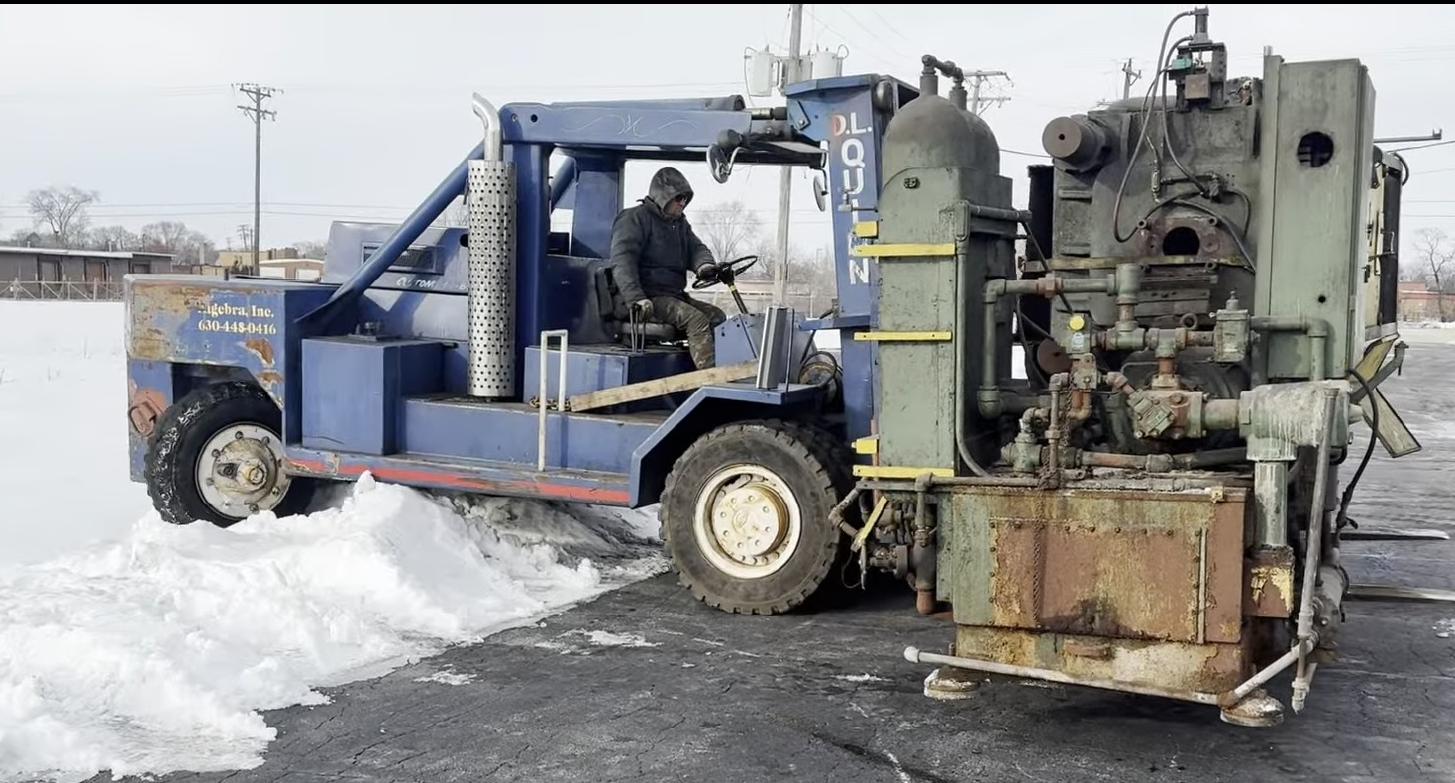 Our heavy forklift carrying a press across a snow-covered lot in the middle of a Chicago winter: the appointment was kept