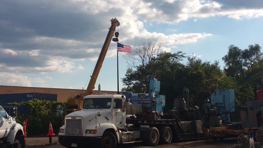 A boom truck making a pick over a loaded lowboy at our yard; single pieces over 160,000 pounds need a real crane crew, not a boom truck or forklifts