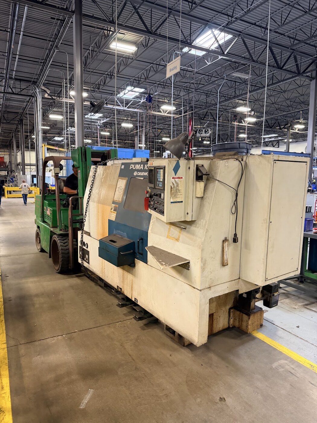 A Daewoo Puma CNC lathe up on skates, being pulled by one of our forklifts