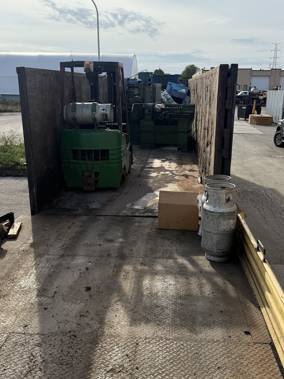 Looking from the platform deck into the gondola, the forklift driving in over the deck to load scrap machinery