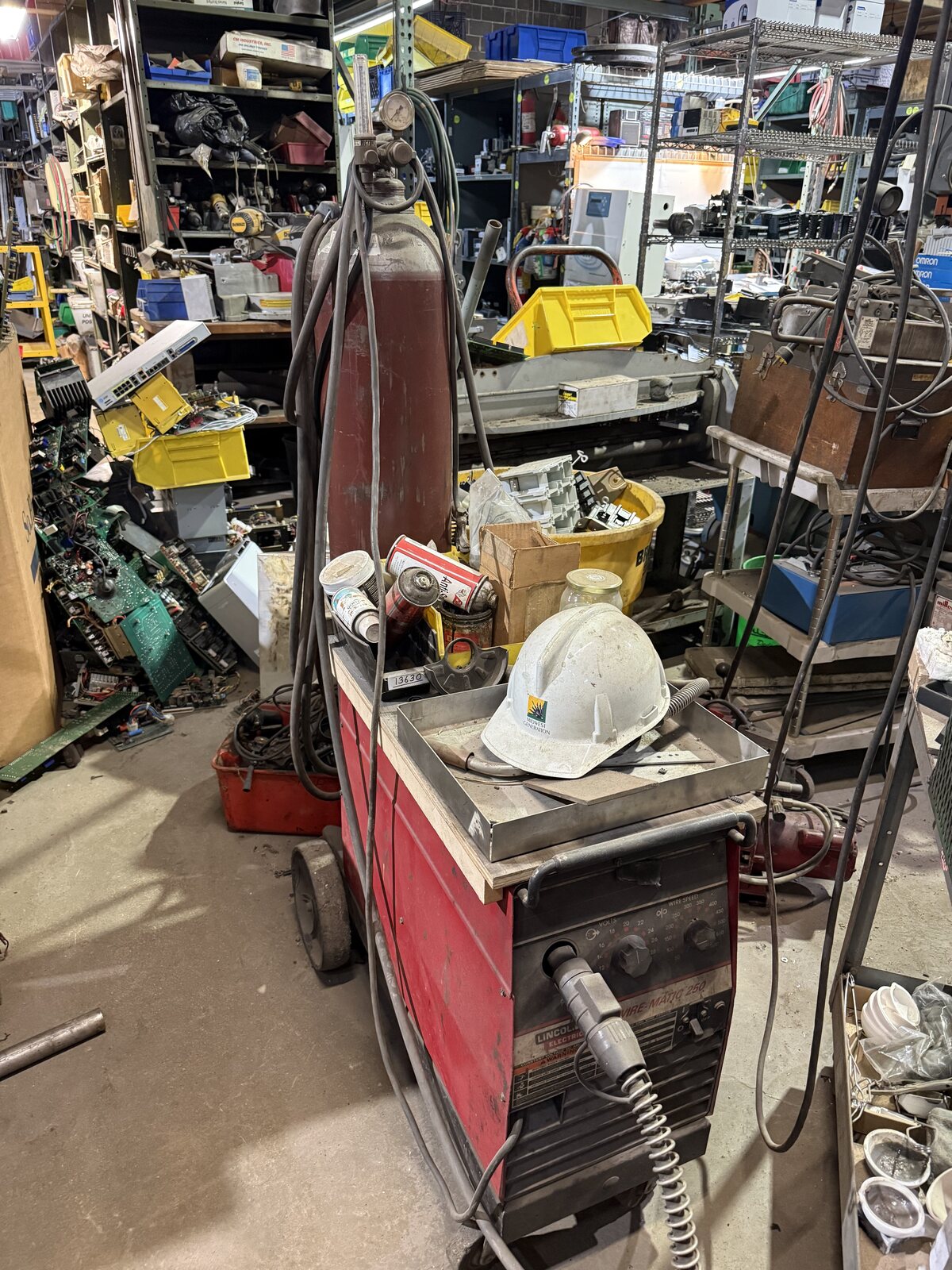 The red Lincoln MIG welder with its shielding gas bottle