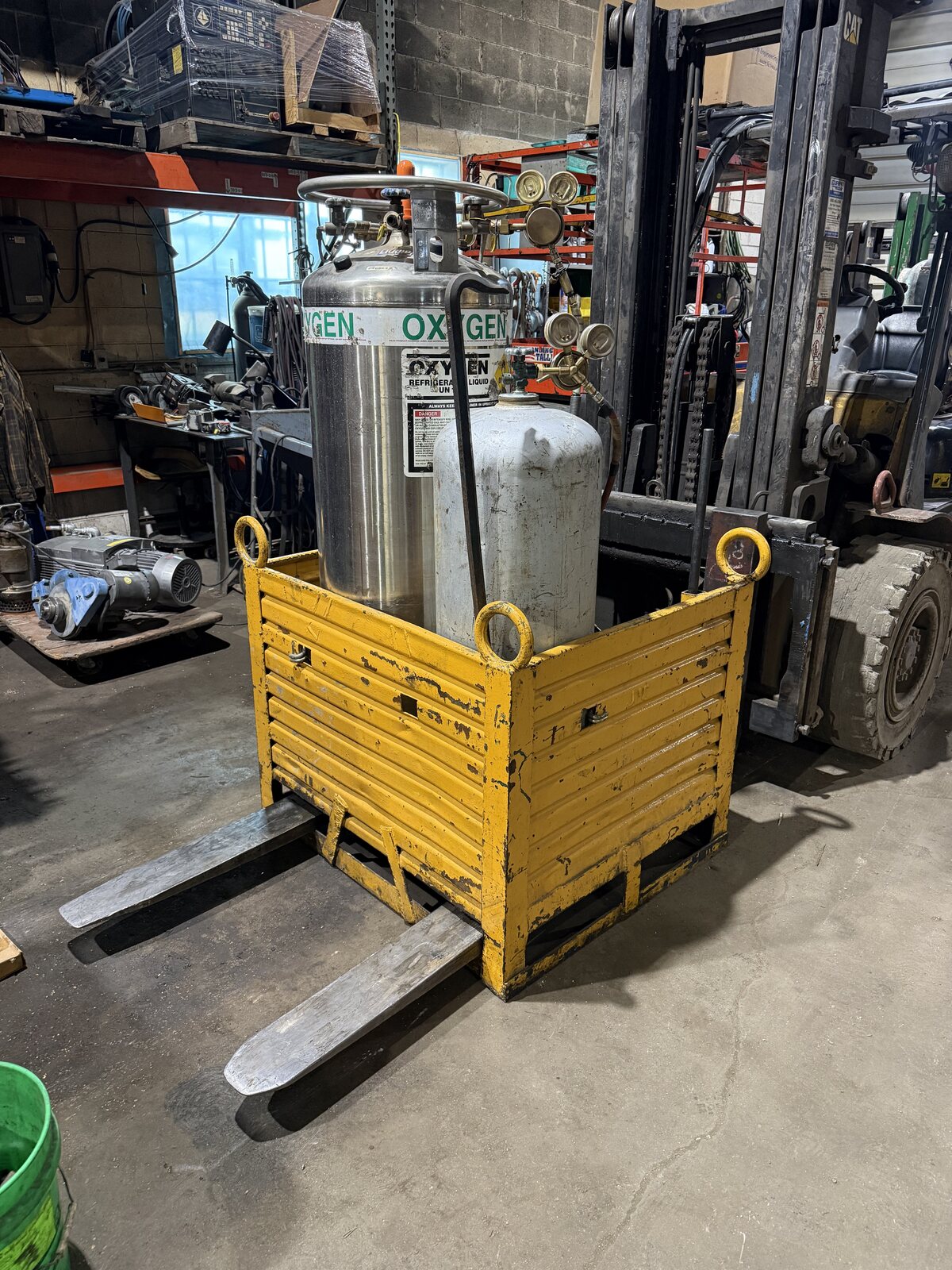 The yellow steel box we built to carry the liquid oxygen tank and a fuel bottle, sitting on the forks of a forklift