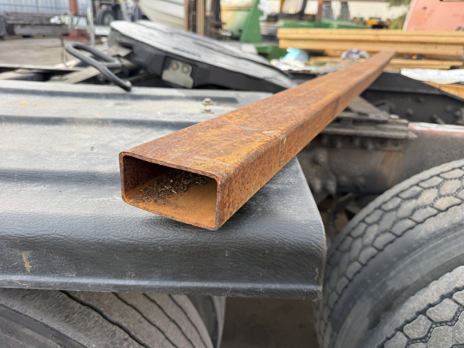 A length of rectangular steel tube laid across the truck frame, the stock for the new ramp