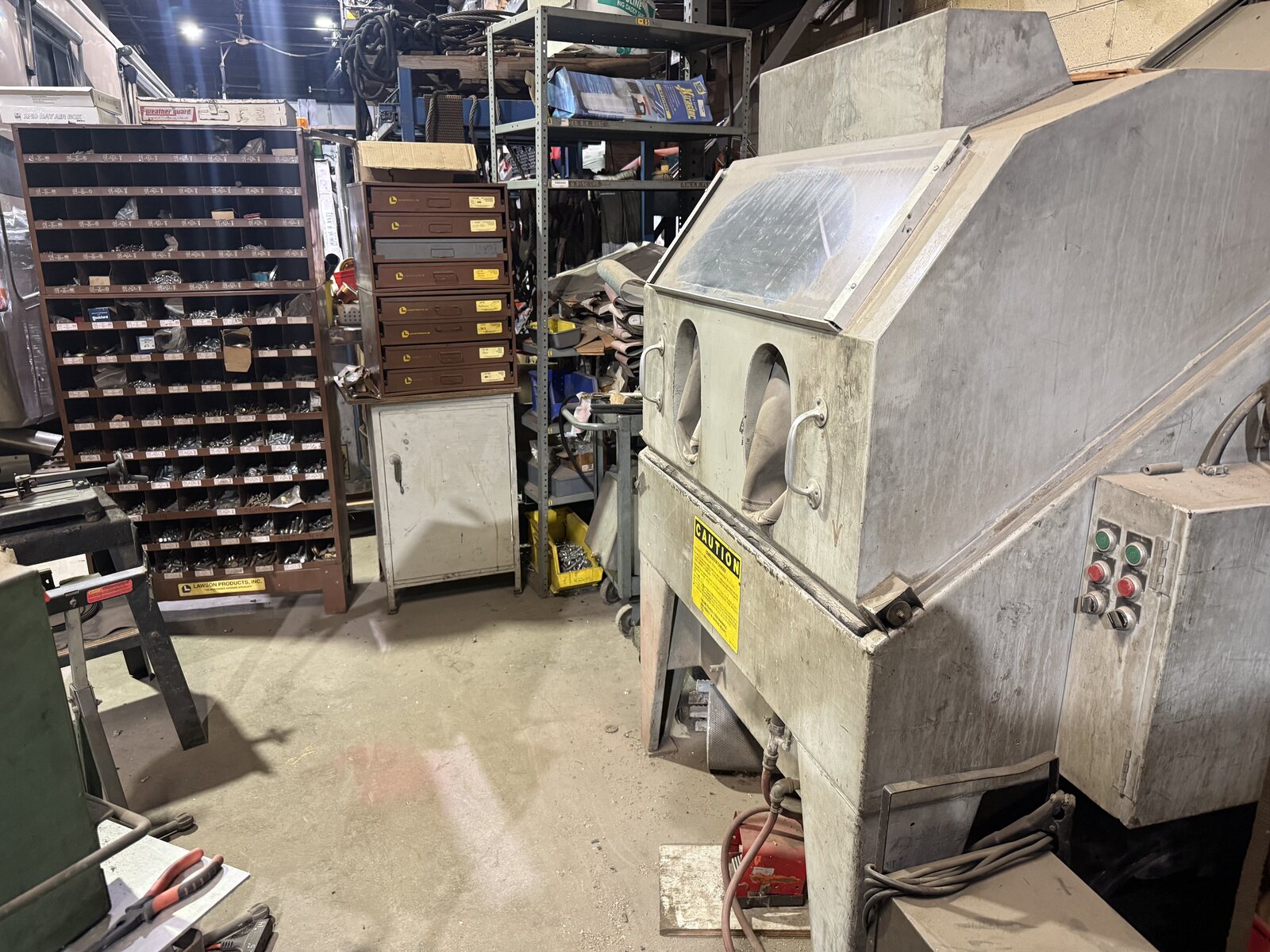 The sand blasting cabinet in front of the hardware bins