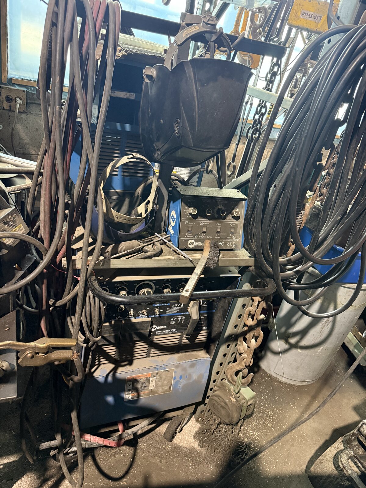 The Miller Syncrowave 250 TIG welder with the pulser on top and leads hanging around it