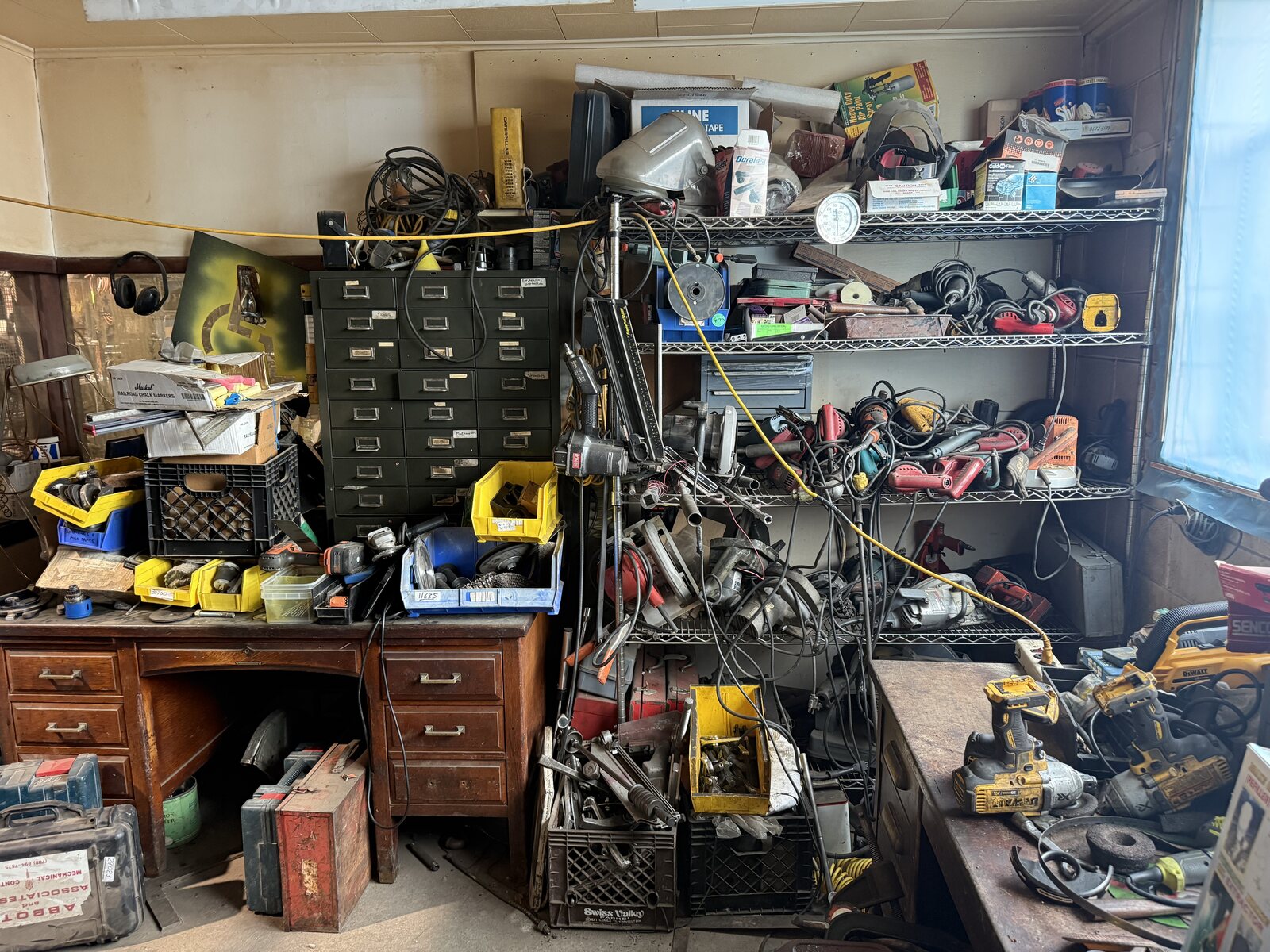 More of the tool room, shelves of power tools above a desk