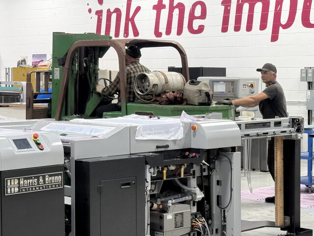 Our green forklift and two men beside a Harris & Bruno machine