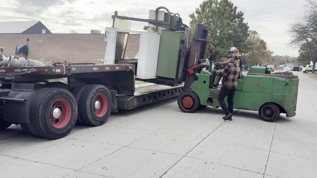 Setting the machine on the lowboy trailer behind our red Peterbilt tractor (19 second video, no sound)