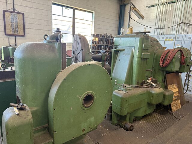 More old green machines with large round housings on the same floor