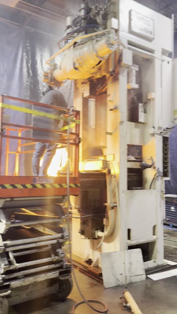 A man on a scissor lift torch-cutting a Verson Hydroform press (5 second video, no sound)
