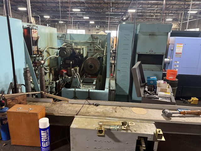 Machines lined up behind a workbench, with an orange tool box in front
