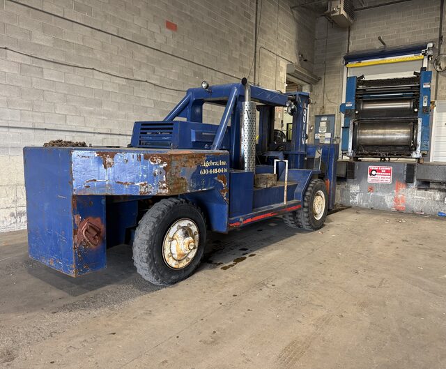 Our blue forklift facing a press unit that stands in the dock door