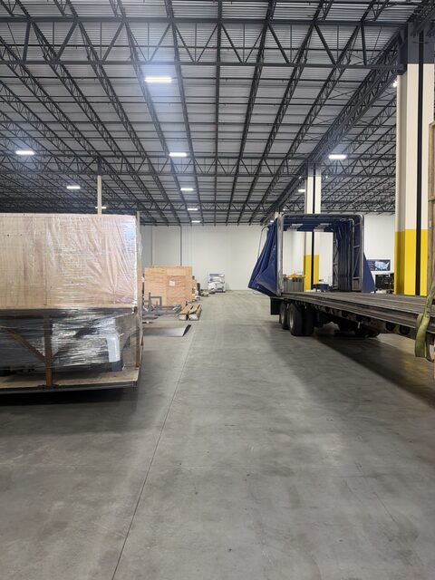 The crated section on the left, and the curtain-side trailer with its curtain gathered at one end