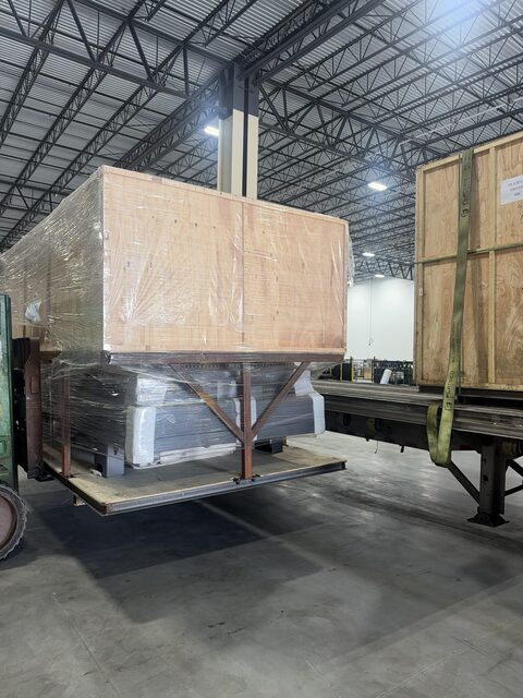 The crated section raised on the forks beside the trailer deck