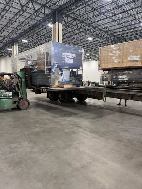 Our forklift at the back of the trailer with the stretch-wrapped HSG laser machine on the deck