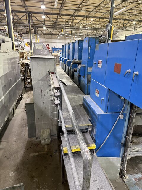 The printing press line in St. Charles that we took apart in March 2026, seen from the walkway along its side