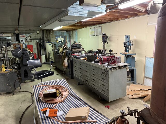 A small shop with a drill press, a band saw and a cabinet of drawers