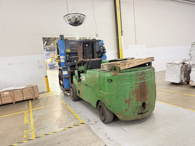 Our Towmotor forklift carrying a press unit through a doorway