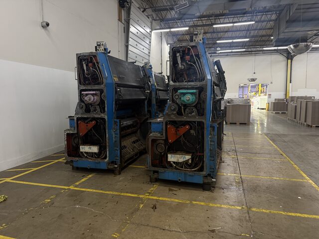 Two press units standing side by side near an overhead door